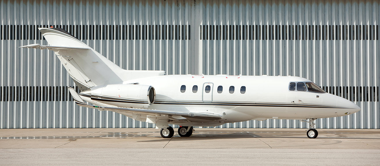 Aircraft parked in front of hangar