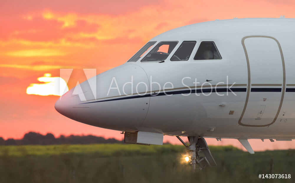 Private business jet on the runway at sunset