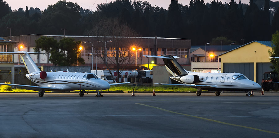 Scenic night view of private business jets standing on parking place